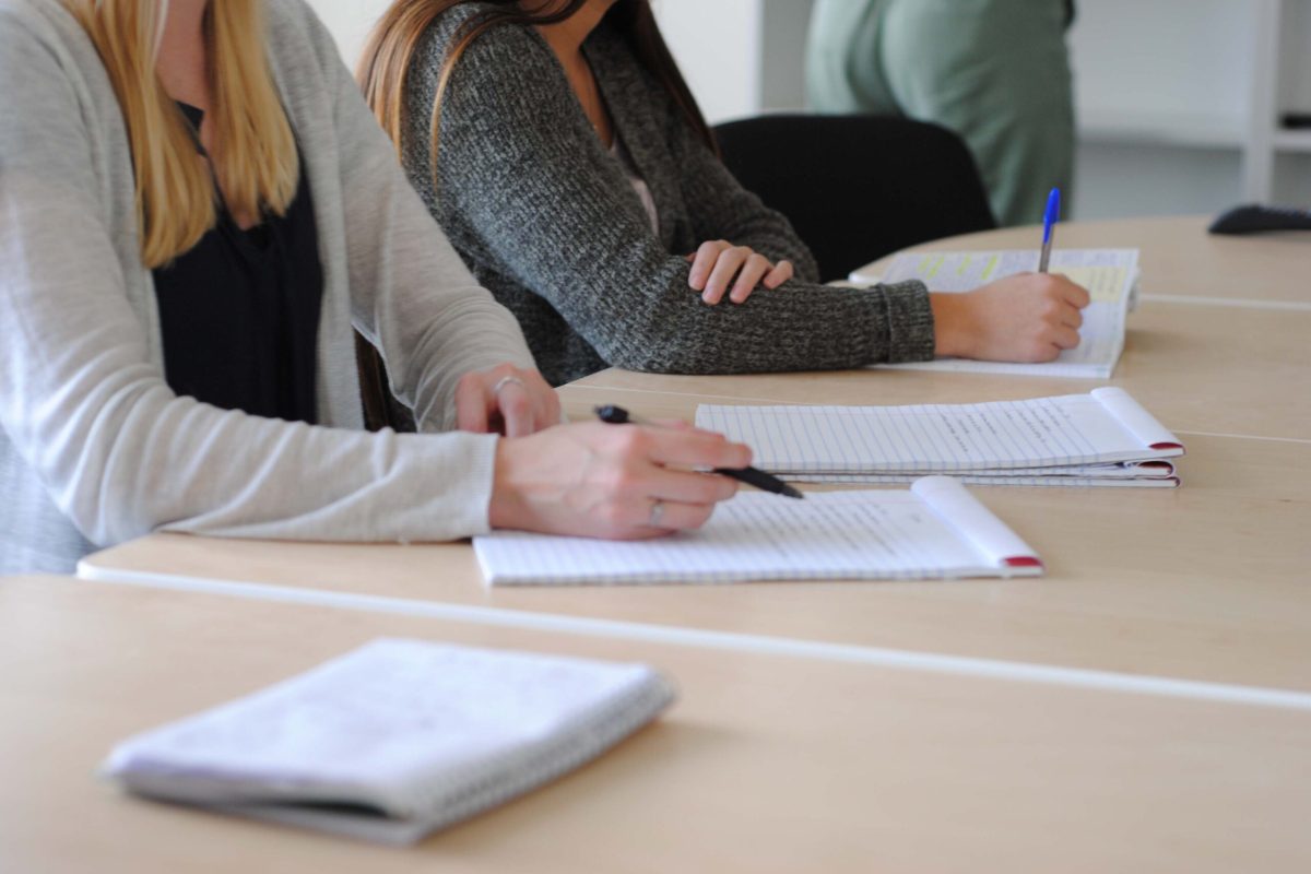 people-sit-with-pads-on-lined-paper-and-take-notes